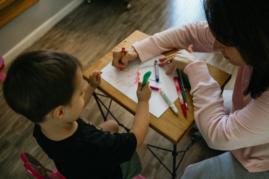 A child working on a creative activity with an adult