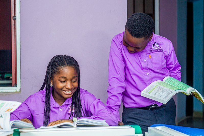 A smiling pupil reading with her tutor